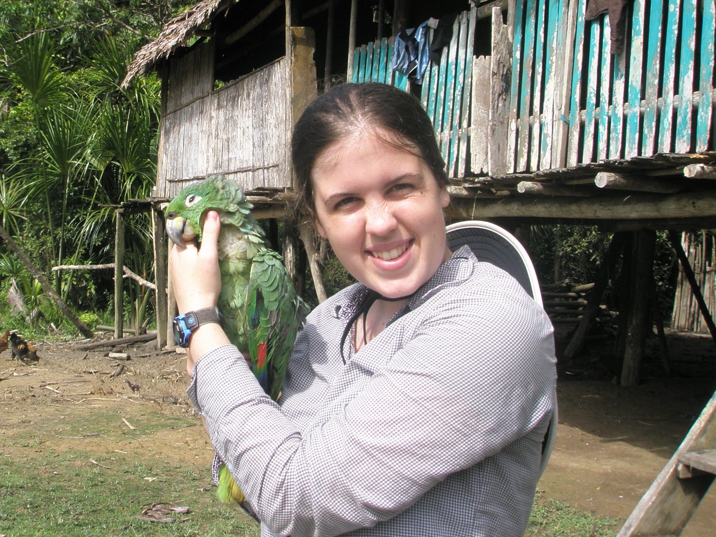 Kelsey holding an Amazon parrot in the field